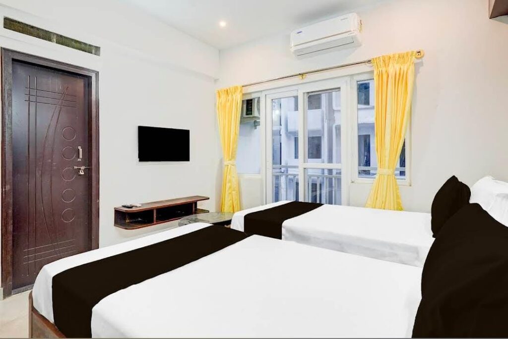 Twin bed hotel room with clean linen and calm lighting at JG Residency Brookefield