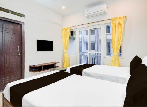 Twin bed hotel room with clean linen and calm lighting at JG Residency Brookefield